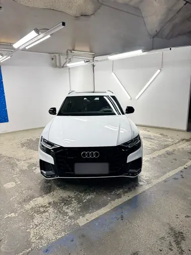 Valkoinen Audi Q8 edestä pesuhallissa