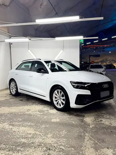 Valkoinen Audi Q8 sivusta pesuhallissa