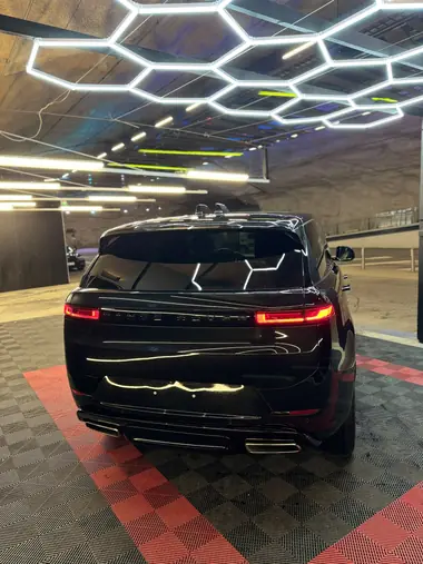Musta Range Rover Sport takaa, kattovalot heijastuvat maalipinnasta